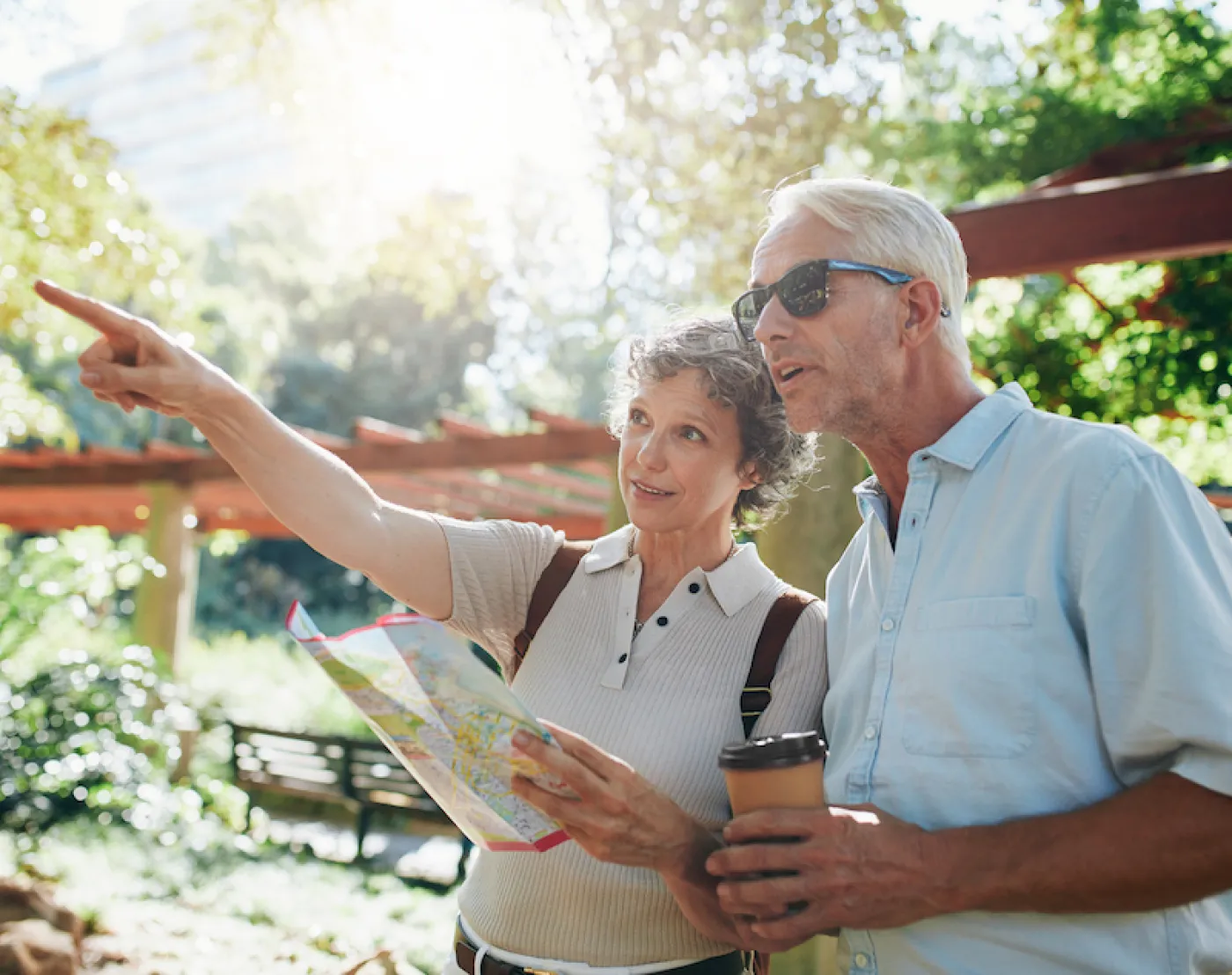 Couple of senior tourists using a city guide searching locations and pointing