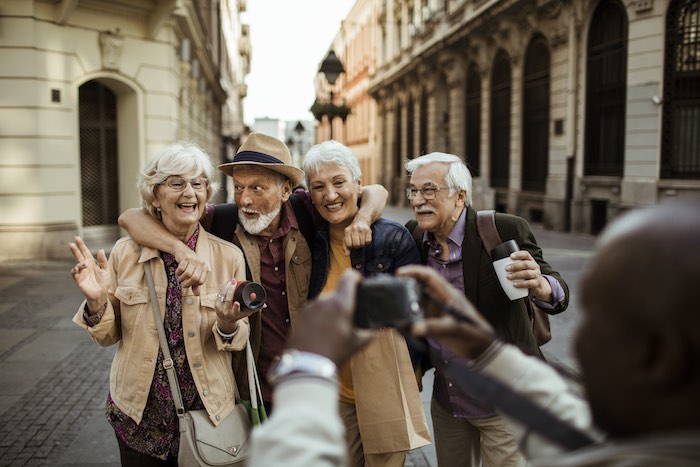 Close up of a group of seniors taking pictures while exploring the city